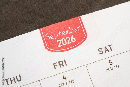 Detail of a calendar page showing September 2026 and highlighted dates. Ideal for planning, organization, and scheduling visuals. Captured in a close-up shot.