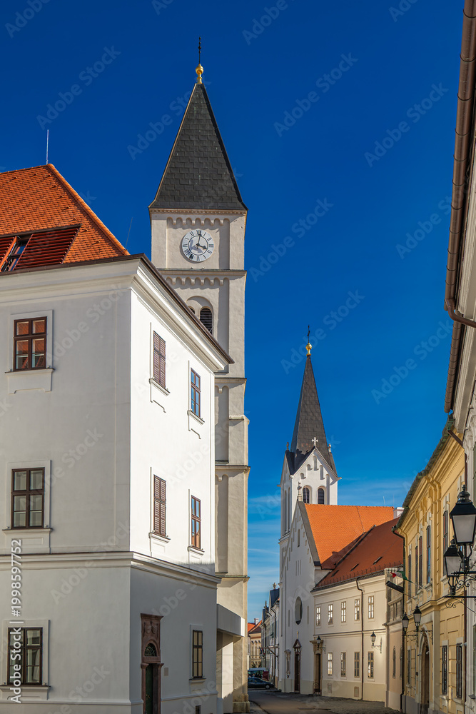 Obraz premium Church tower clock historic architecture street in the castle district of Veszprém, Hungary
