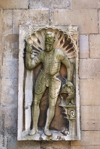 Renaissance Stone Relief of Noble Knight in Full Armor on External Wall of St Martins Cathedral in Bratislava Slovakia featuring Detailed Carving of Warrior with Helmet and Shell Ornamentation.