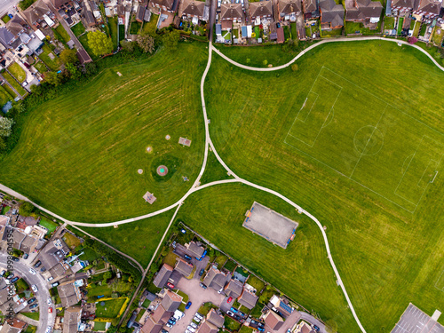 Aerial view directly above a large UK housing estate with community playing field and park