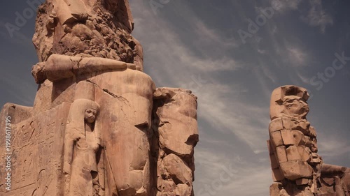 Colossi of Memnon, Luxor, Egypt – iconic ancient statues. Cinematic footage of the Colossi of Memnon in Luxor, Egypt, showcasing the massive ancient stone statues from various angles.