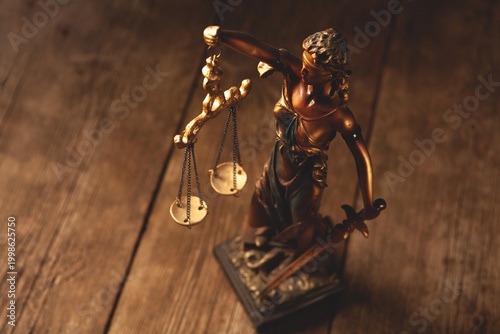 Statue of justice on wooden background. Law and justice concept.