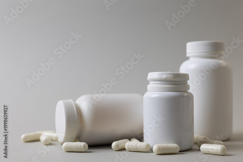 Vitamins On Neutral Background. Assorted Supplement Bottles With Capsules On Plain Backdrop