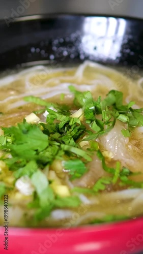 Delicious bowl of fresh pho with herbs served in Hanoi, Vietnam, a must-try local specialty for food lovers
