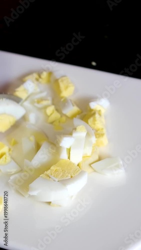 Eggs chopped fast. Closeup of hands chopping boiled eggs into small pieces carefully. Bright countertop setting with hands precisely dicing cooked eggs for culinary preparation