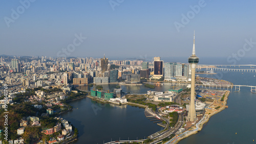 Macao - 18 February 2026: Aerial view of the Macau Tower and the city skyline including the Grand Lisboa hotel overlooking Nam Van Lake under a clear blue sky.