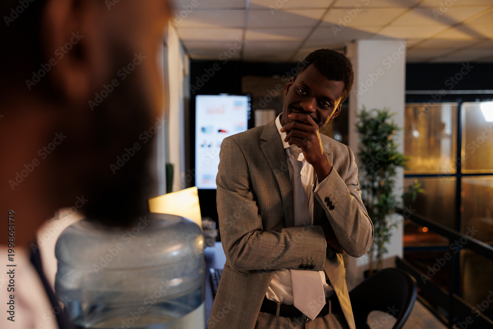Fototapeta premium Relaxed businessman discussing company profit with manager during work break in startup office. Employees working late at night, planning investment strategy plan. Business concept