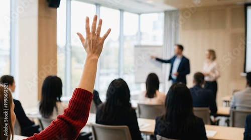 Engaged professional raising hand in modern business conference session