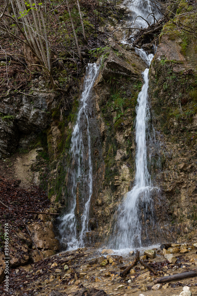 Fototapeta premium Small Waterfall Flowing Over Rocky Cliff
