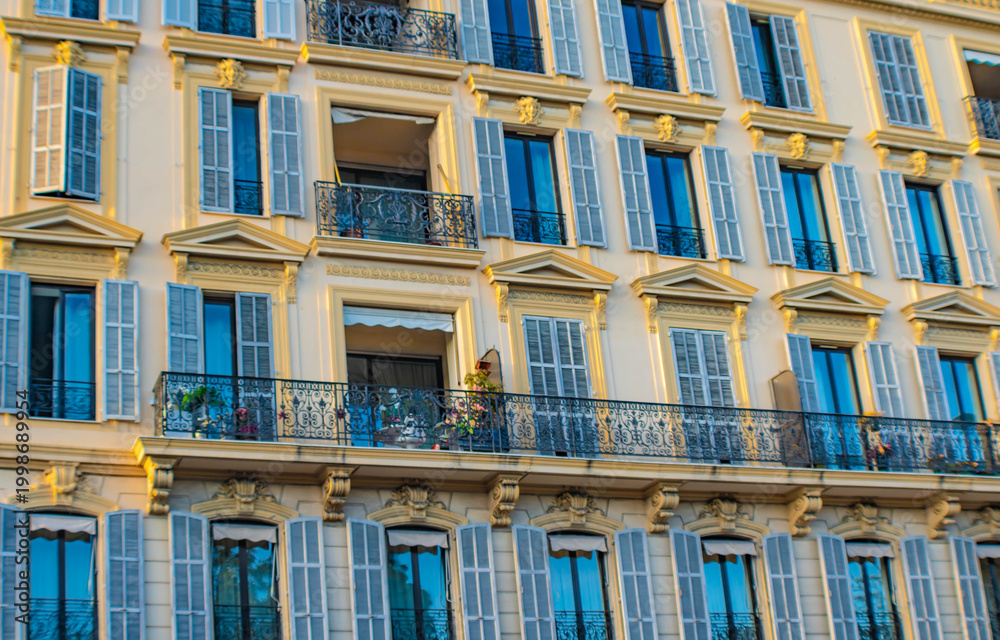 Fototapeta premium Close up of a yellow building with turquoise shutters, full frame, NIce, France