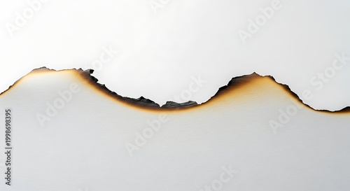 Burnt edge of paper with dark brown and black scorch marks