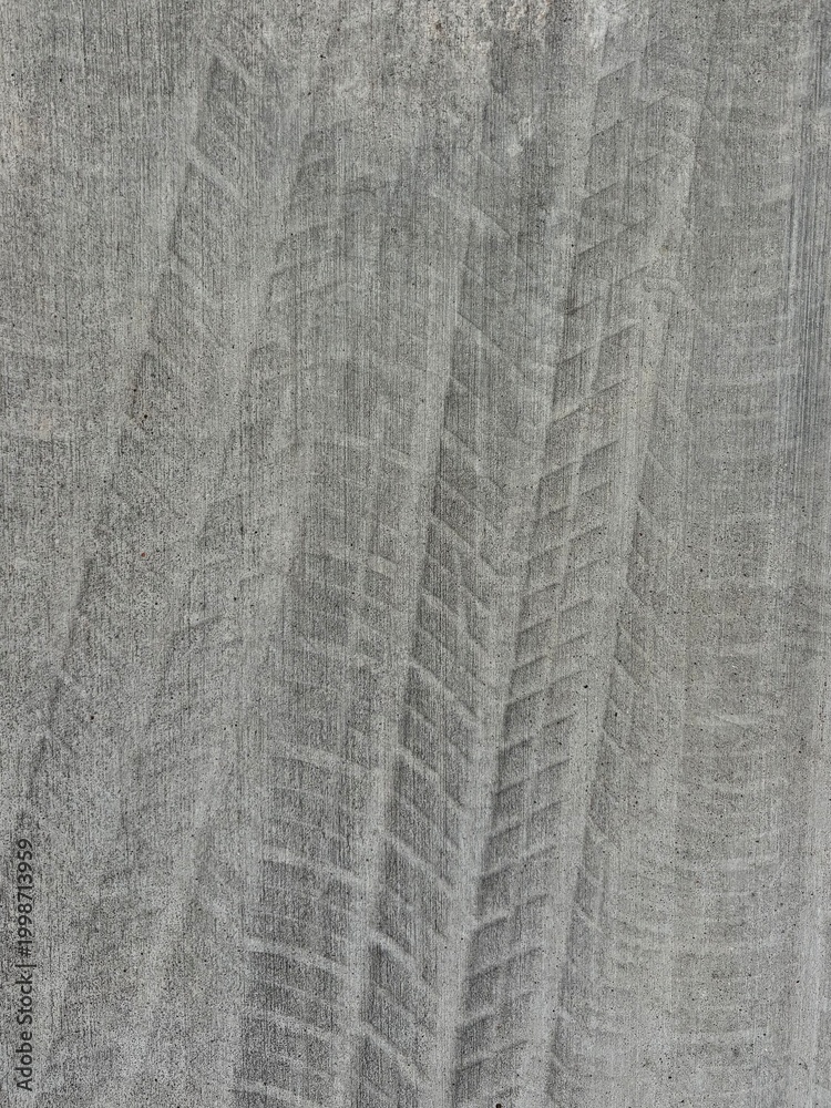 Obraz premium Tire Tread Marks Imprinted on Gray Concrete Surface Urban Pattern Background