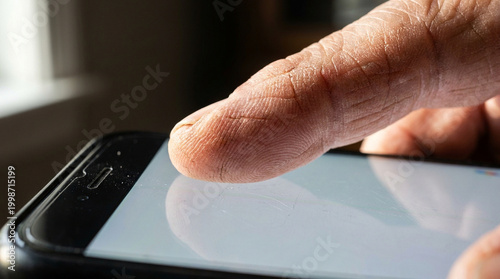 Digital divide elderly hand pressing smartphone screen macro detail