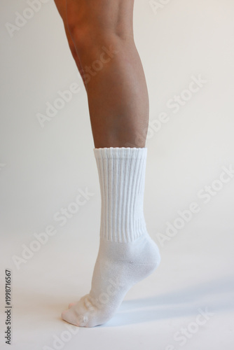 Female Legs Wearing White Ribbed Crew Socks Side View Minimal Studio Shot