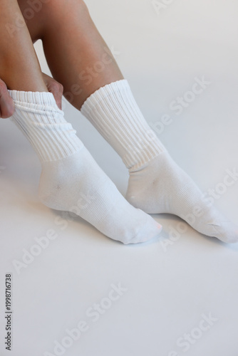 White Ribbed Crew Socks on Female Legs on White Background