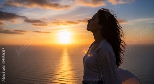 広がる海と空が織りなす夕焼けの絶景を背景に立つ女性の横顔 輝く黄金色の夕日を全身で浴び髪も美しく輝く深く感動的な瞬間 穏やかな表情が静かな安らぎと自由を伝える. AI Generated