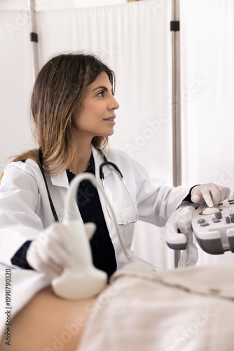 Canvas Print Focused female doctor performs abdominal ultrasound scan