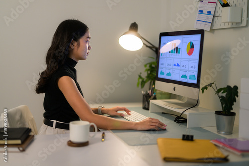 Tableau sur toile Young woman analyzing business data on computer at night