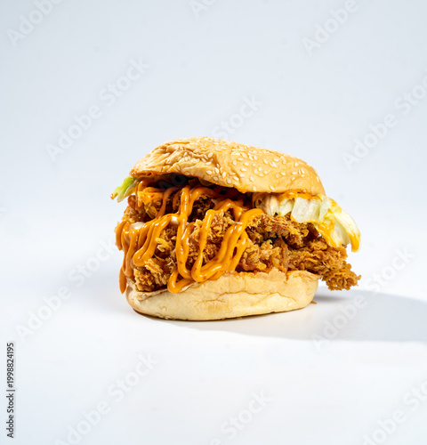 Hand holding a fried chicken burger isolate on white background