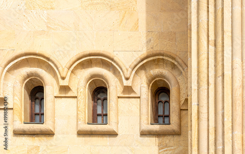 Photos Architectural Elegance: A close-up view showcasing the intricate facade of a classical building with an arrangement of arched windows, paired with a stately column