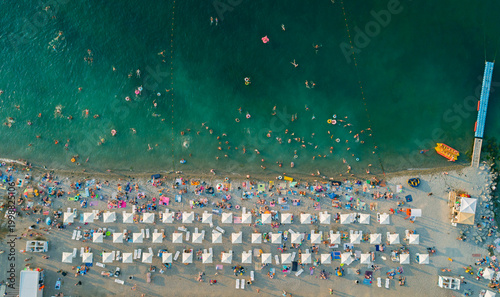 Bilde på lerret Aerial view of a vibrant beach filled with bathers enjoying warm water and sun u