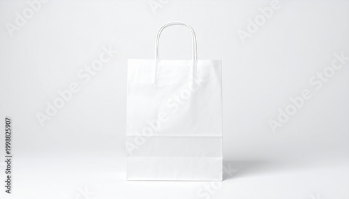 Front view of a white paper shopping bag with handles on a light grey background