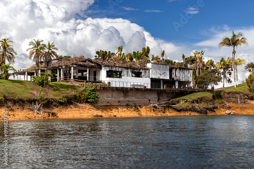 Tablou pe pânză Rusted structure stands by calm water's edge