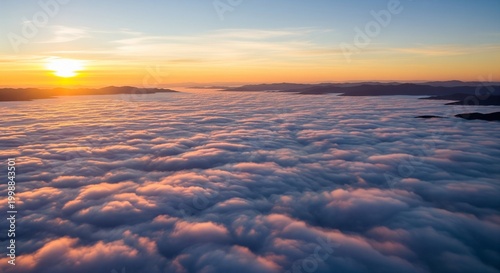 Golden sunrise over a sea of clouds with mountain silhouettes creating a serene skyscape and soft light in a dreamy aerial view