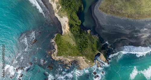 Canvas-taulu Aerial view of the rugged coastline where the Tasman Sea meets the black sands of the North Island in Waikawau, New Zealand