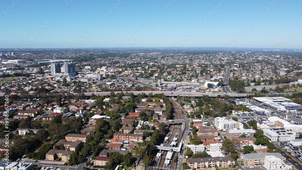 Fototapeta premium Aerial view of suburbs commercial district and train station
