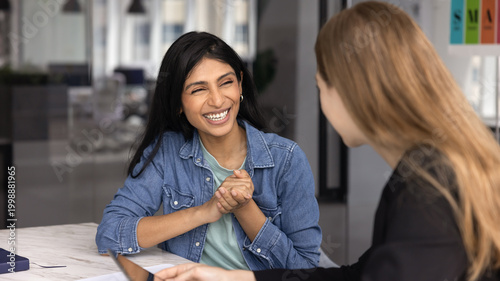 Картината върху платно Women colleagues chatting during informal meeting in modern office, laughing, radiating enthusiasm and positivity in workplace during break and casual conversation