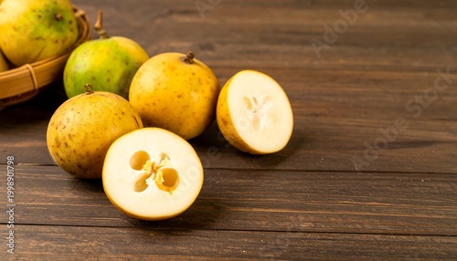 Several yellow-skinned fruits, some halved, rest on a dark wooden surface. A woven basket holds more. The fruit shows a unique interior