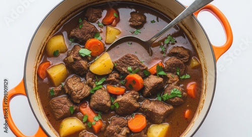 Hearty beef stew in orange dutch oven with fresh parsley, a warming meal for cold weather.