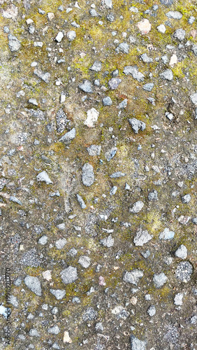 Close-up view of rough asphalt road surface with small stones and gravel texture. Concrete pavement of the pedestrian road