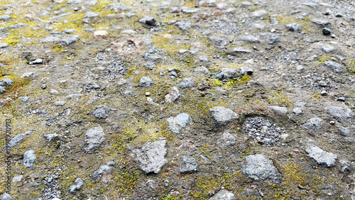 Close-up view of rough asphalt road surface with small stones and gravel texture. Concrete pavement of the pedestrian road