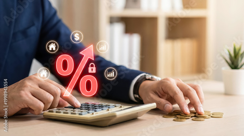 Businessman using calculator with rising interest rate percentage symbol and financial icons