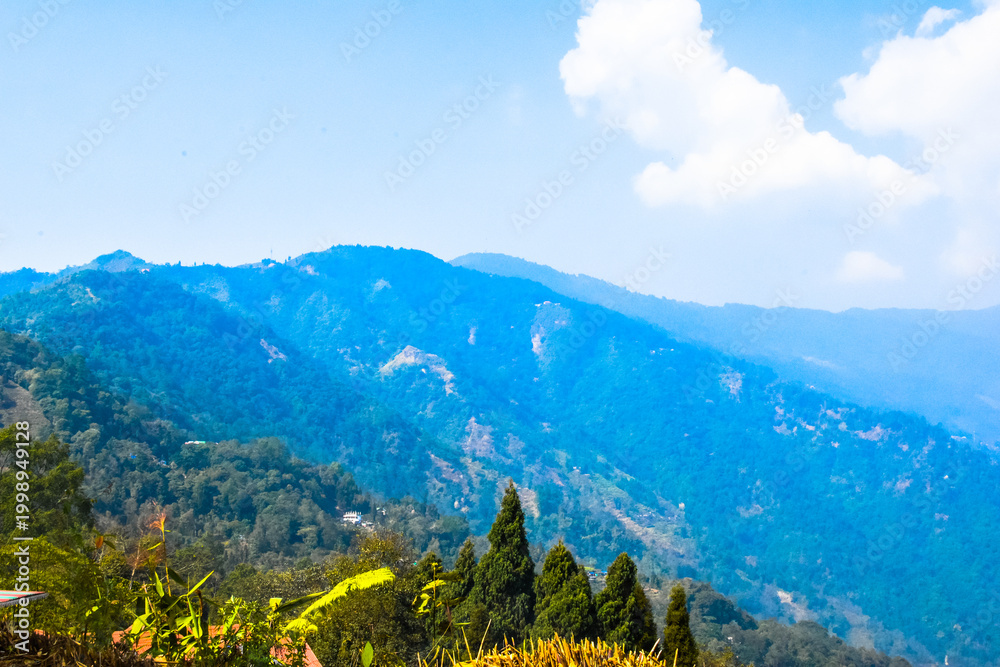 Fototapeta premium Panoramic view of Sittong, Darjeeling, West Bengal, India. Panoramic view of blue mountains peaks ridge.