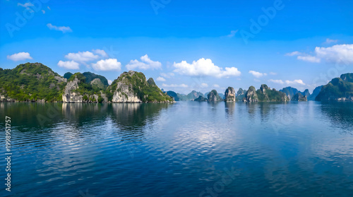 Fotografi Limestone karsts in Halong Bay with calm blue water reflections
