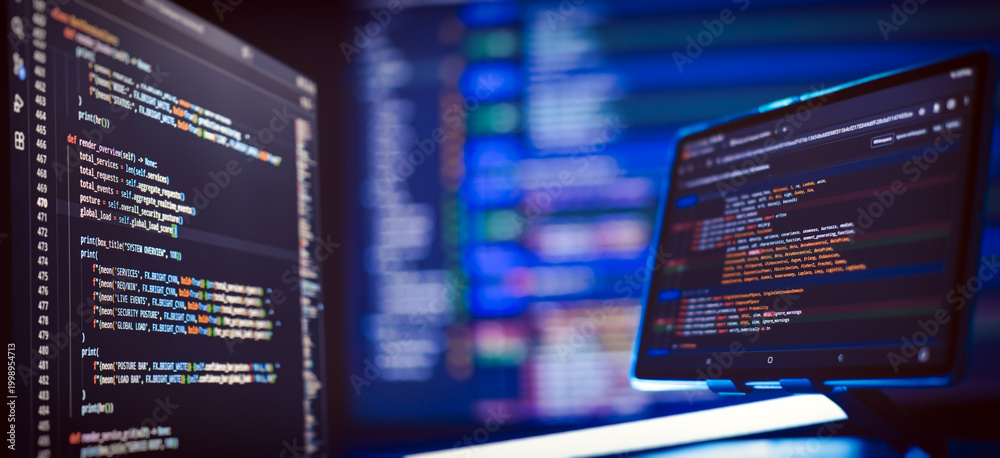 Naklejka premium Cyber security concept and hacking. Multiple monitors with complex colorful script syntax in dark mode with shallow depth of field.