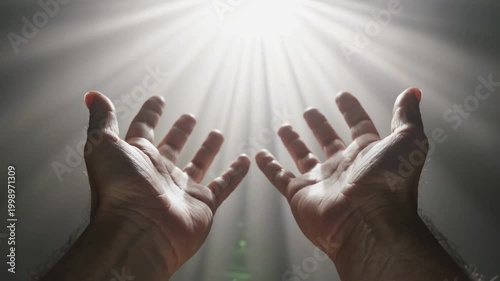 Hand reaching toward a radiant light, symbolizing hope, guidance, and the promise of a brighter future
