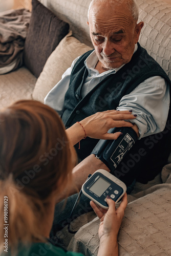 Картината върху платно healthcare professional in uniform and wearing a stethoscope takes an elderly pe