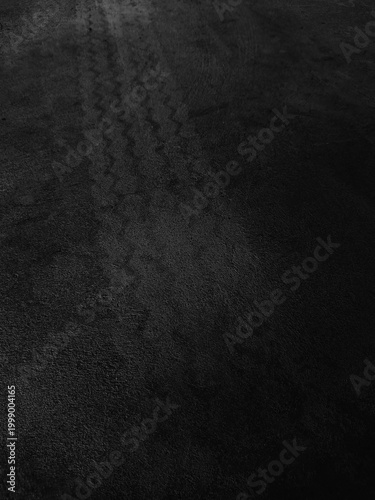 Close up black tire marks on cement floor.