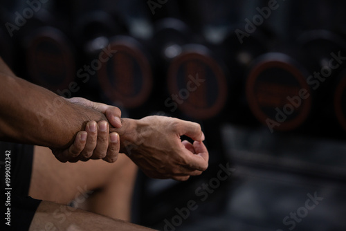 Fitness gym wrist hand stretching athlete bodybuilder closeup injury or pain