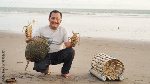 Tableau sur toile balinese fisherman with two lobsters in tabanan, bali, indonesia, caught at sea