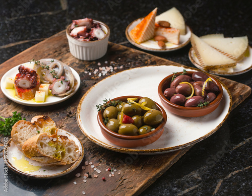 45-degree angle view of Spanish tapas variety presented in a vibrant flat lay arrangement.