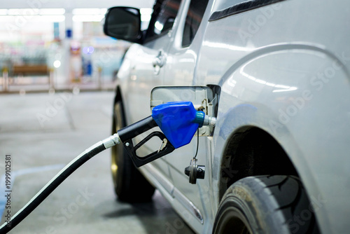 Cuadro en lienzo Blue fuel nozzle fueling a car in gasoline stations.
