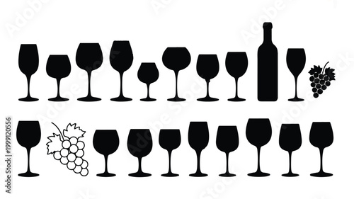 A collection of wine glasses and bottles with grapes arranged in two rows on a table indoors