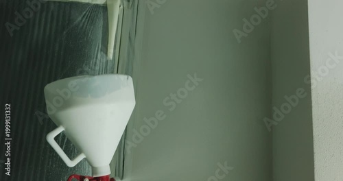Spraying paint onto wall with spray gun during interior finishing close up