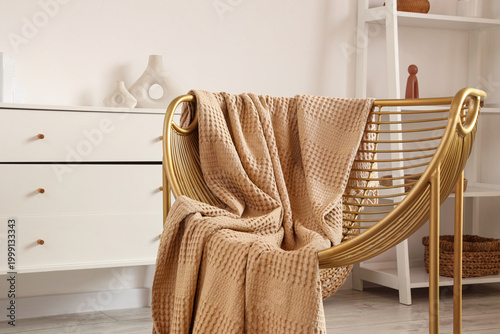 Golden armchair with plaid ...