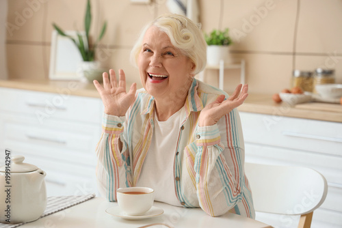 Happy senior woman at table...